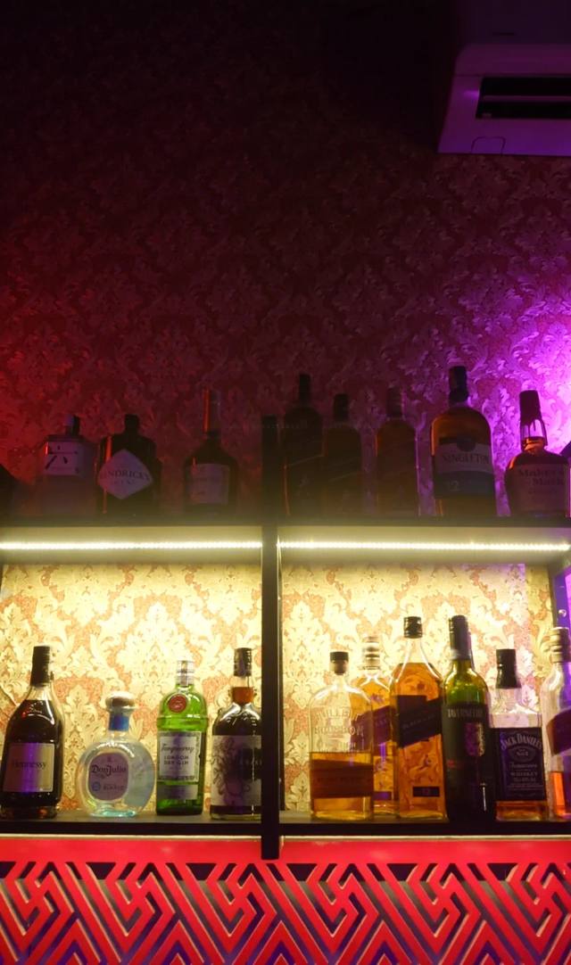 Kong 72 的吧台：背光酒架与粉色霓虹